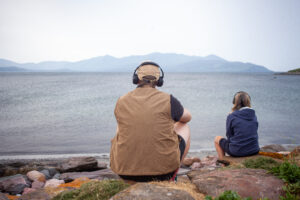 Person sitting looking out to sea with hardphones