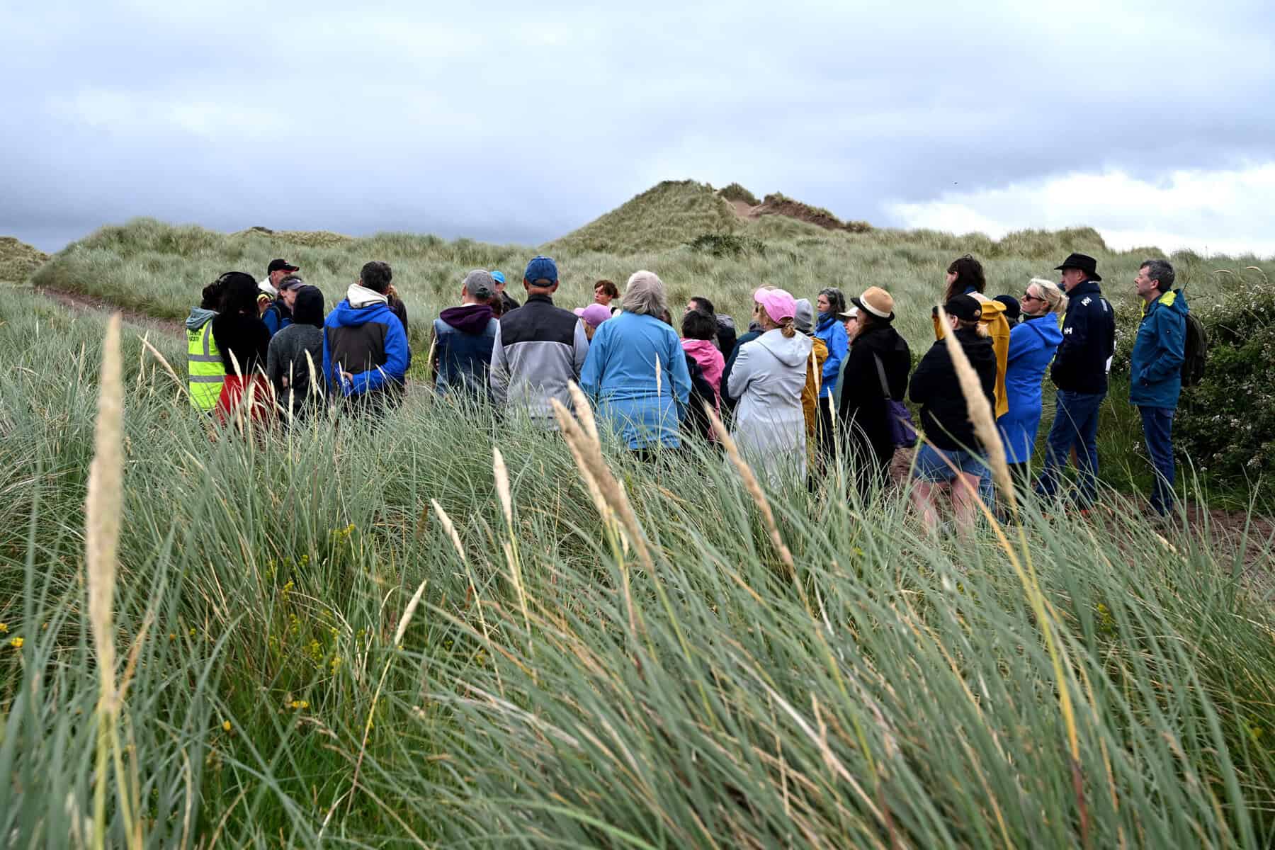 Group of people walking in the sand dunes in the Maharees